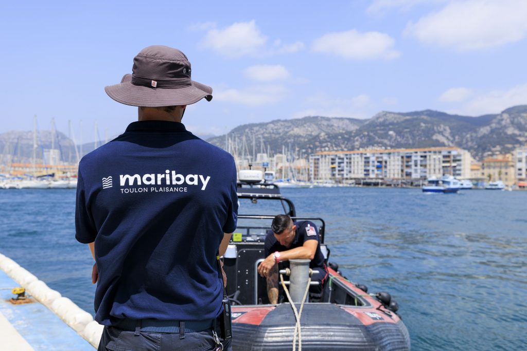Membre de l'équipe du Port de Toulon Vieille Darse de dos regardant un bateau à moteur en train de se ravitailler en carburant
