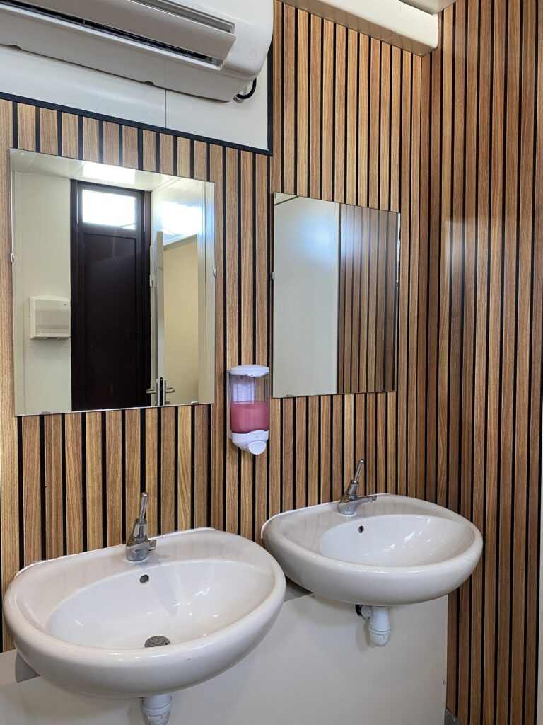 Photo des sanitaires présentant deux lavabos et un miroir